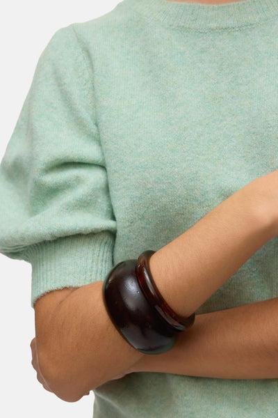 Groene trui met ronde hals van VERO MODA® gedragen met een brede bruine armband.