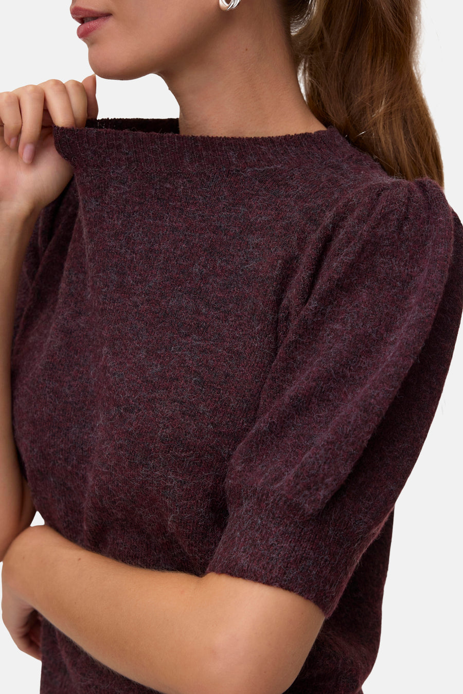 Gros plan sur un pull col O bordeaux à manches longues VERO MODA® porté par un mannequin.