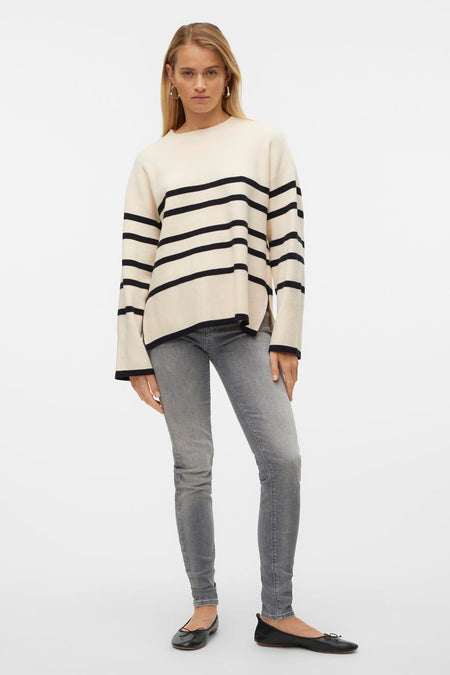 Beige trui met zwarte strepen van VERO MODA®, gedragen met een grijze jeans en zwarte ballerina's.