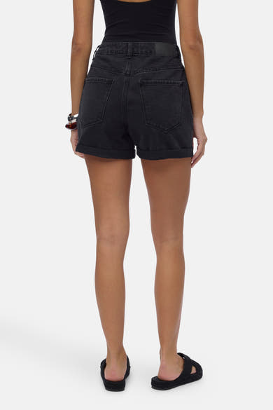 Short noir en jean de Vero Moda, avec ourlet retroussé et poches arrière visibles.
