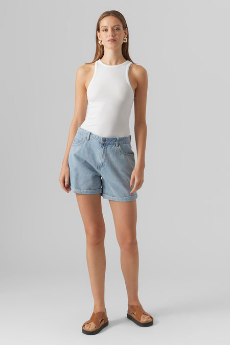 Short bleu décontracté de Vero Moda, porté avec un débardeur blanc et des sandales en cuir marron.