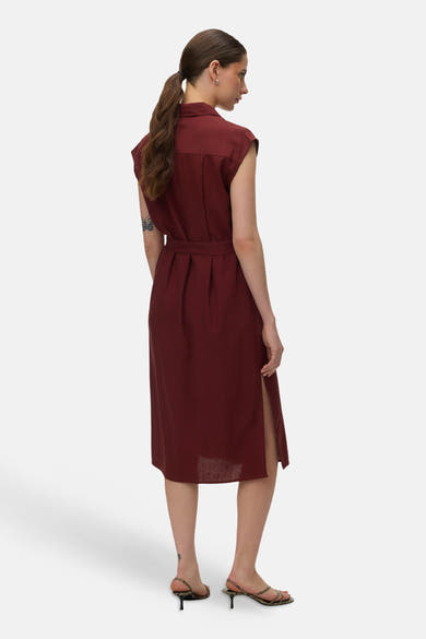 Bakstenen jurk van VERO MODA, met een strikceintuur en een zijsplit, van achteren gezien.