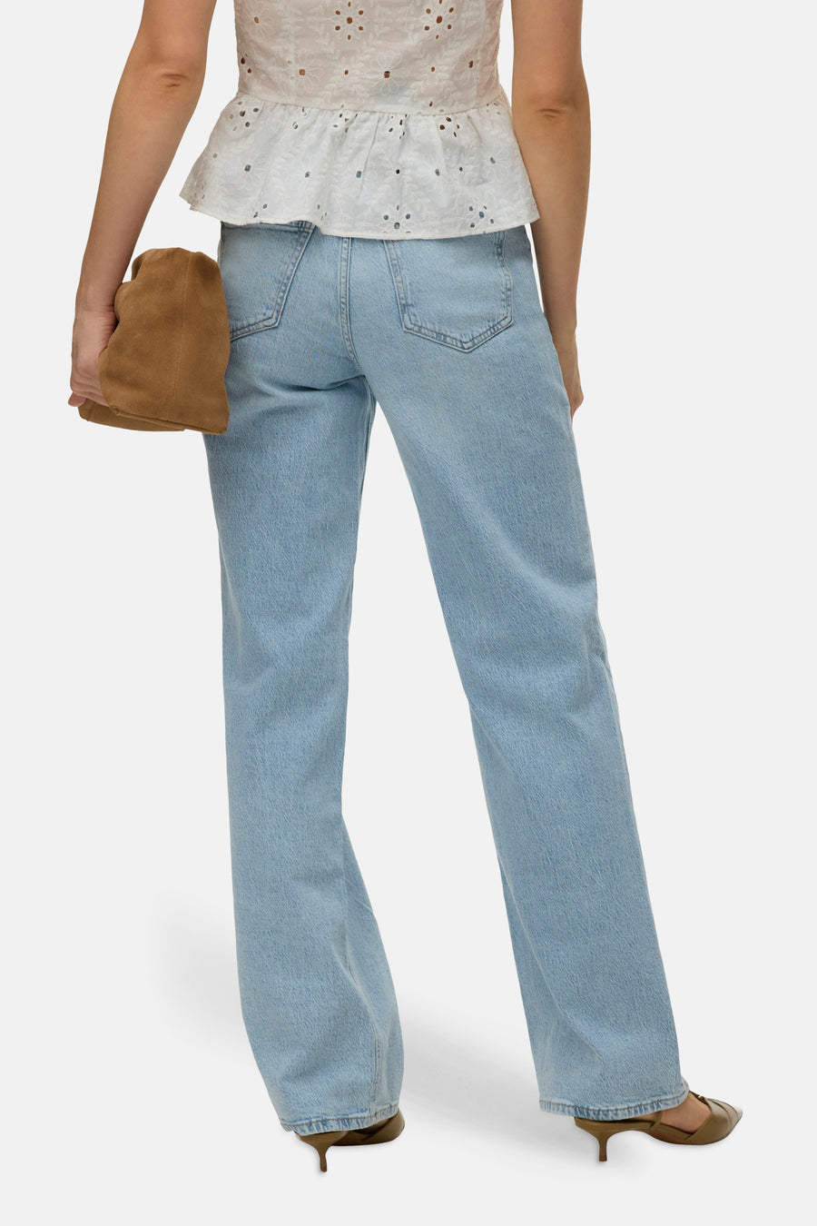 Jean droit bleu de VERO MODA, porté avec un haut blanc brodé et un sac marron.