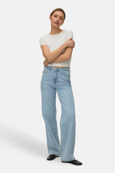 Jean droit bleu de VERO MODA, porté avec un t-shirt blanc uni et des ballerines noires.