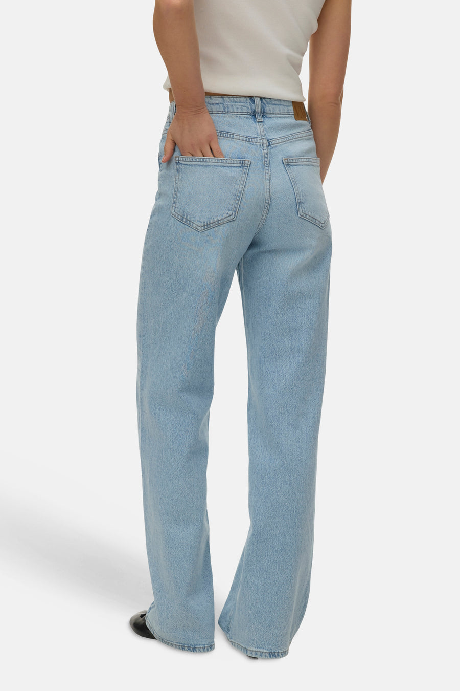 Jean droit bleu de VERO MODA, avec une personne portant un haut blanc et des chaussures noires.
