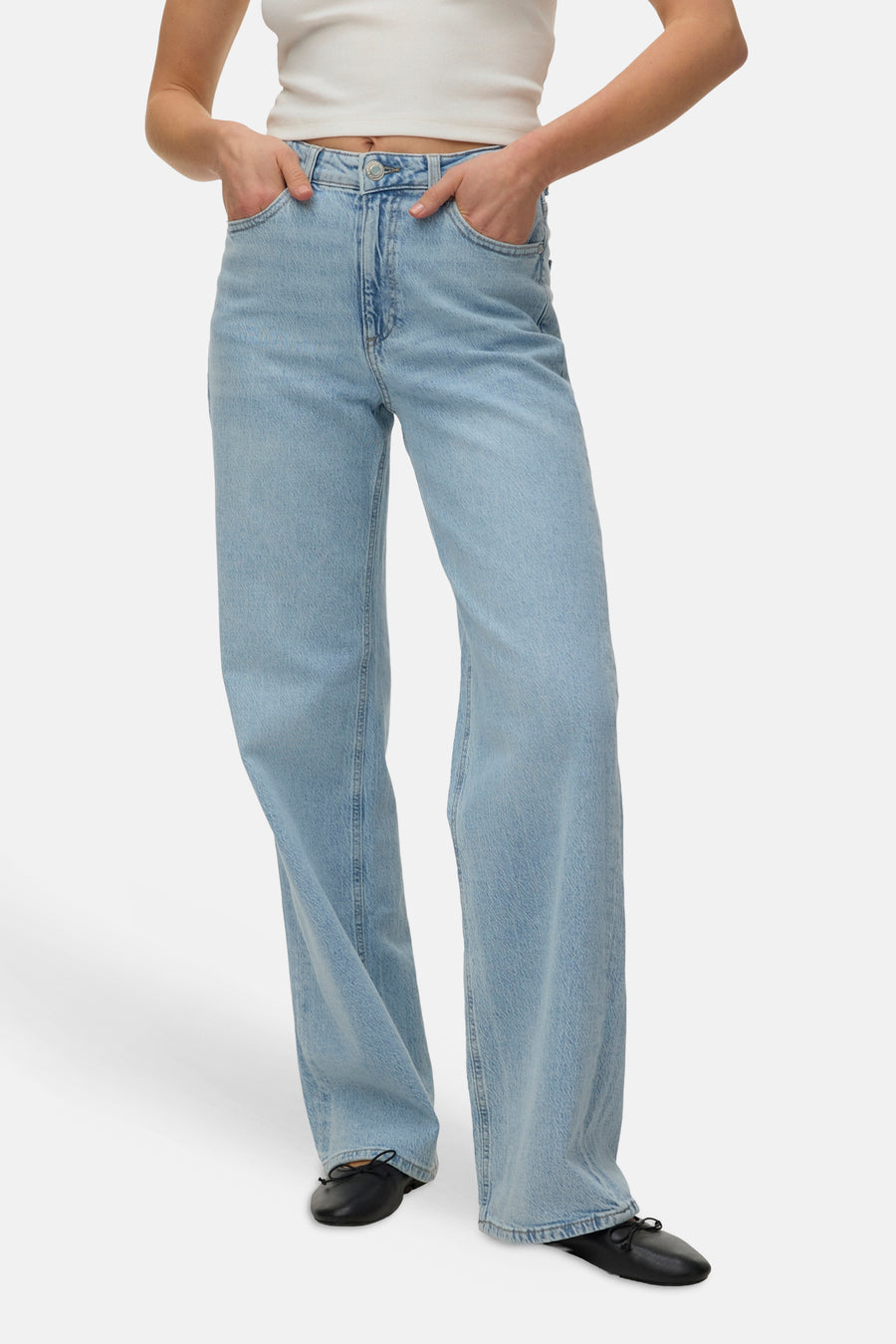 Jean droit bleu de VERO MODA, porté avec un haut blanc et des ballerines noires.