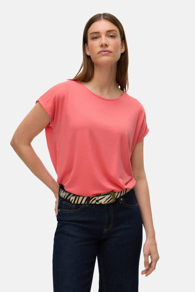 Koraalkleurig T-shirt met korte mouwen van VERO MODA, gedragen met een zebraprint riem en een donkerblauwe jeans.