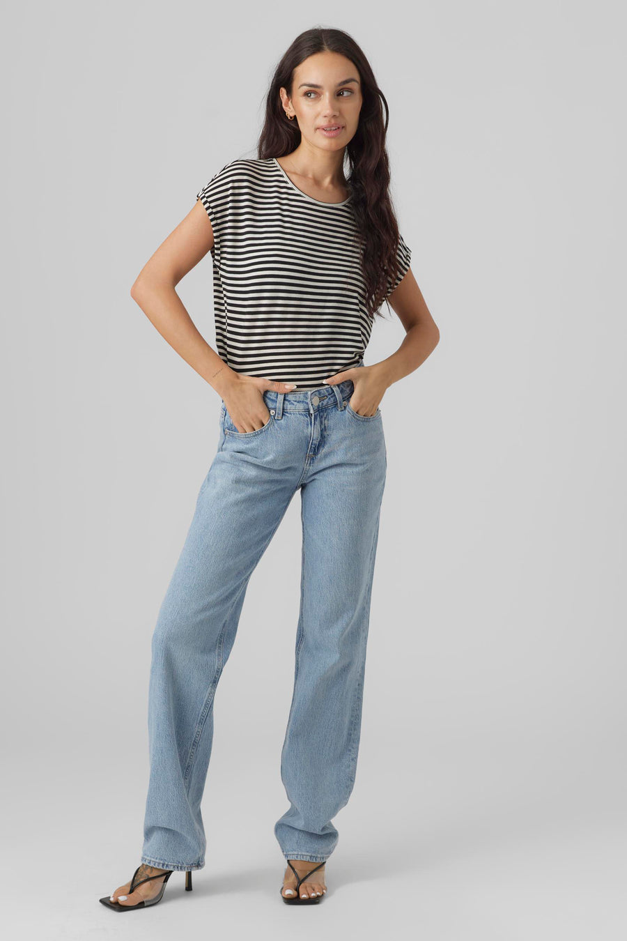 Zwart gestreept T-shirt, van VERO MODA, gedragen met een wijde blauwe jeans en zwarte hakken.