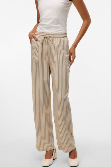 Pantalon beige à rayures fines de VERO MODA, avec cordon de serrage à la taille et chaussures ivoire.
