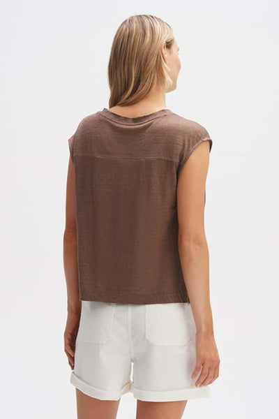 Blouse à manches courtes marron de OPUS, avec un empiècement horizontal et portée avec un short blanc.