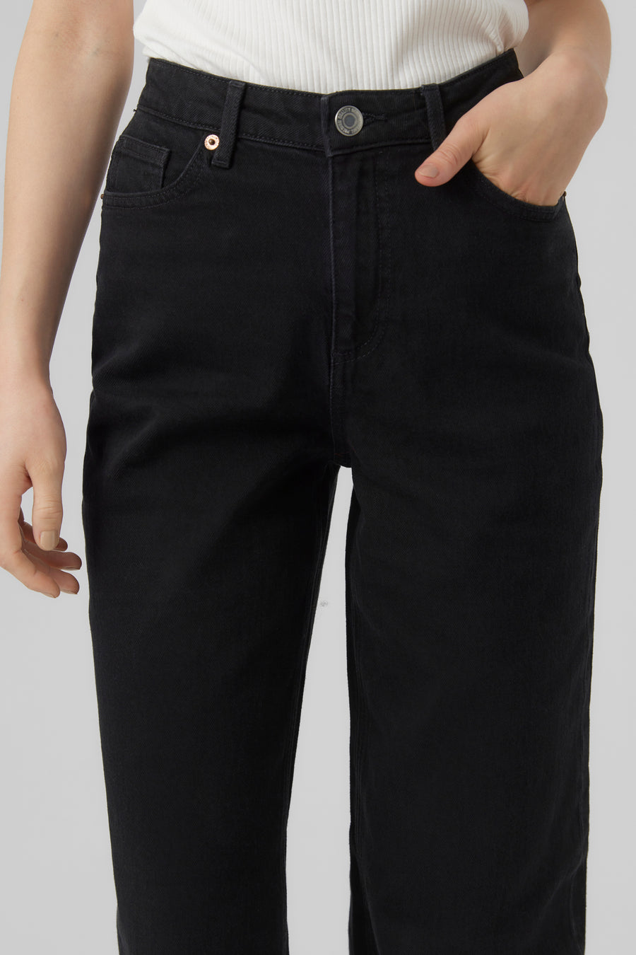 Zwarte rechte spijkerbroek van VERO MODA, met een hand in de zak.