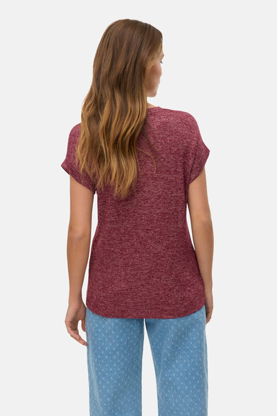 T-shirt rouge à manches courtes de VERO MODA, avec un effet chiné, porté avec un pantalon bleu clair.

