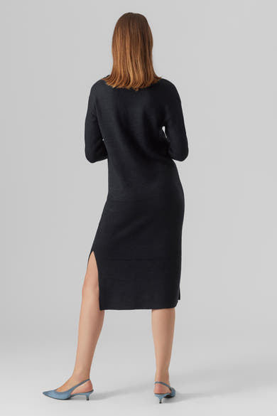 Zwarte midi-jurk van VERO MODA, met een zijsplit en gedragen met blauwe pumps.