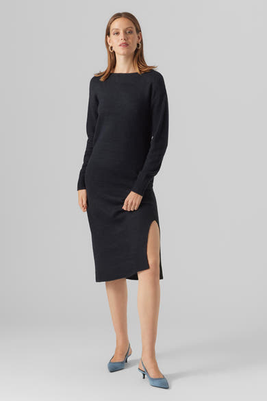 Zwarte midi-jurk van VERO MODA, met lange mouwen en een split aan de zijkant, gedragen met blauwe pumps.
