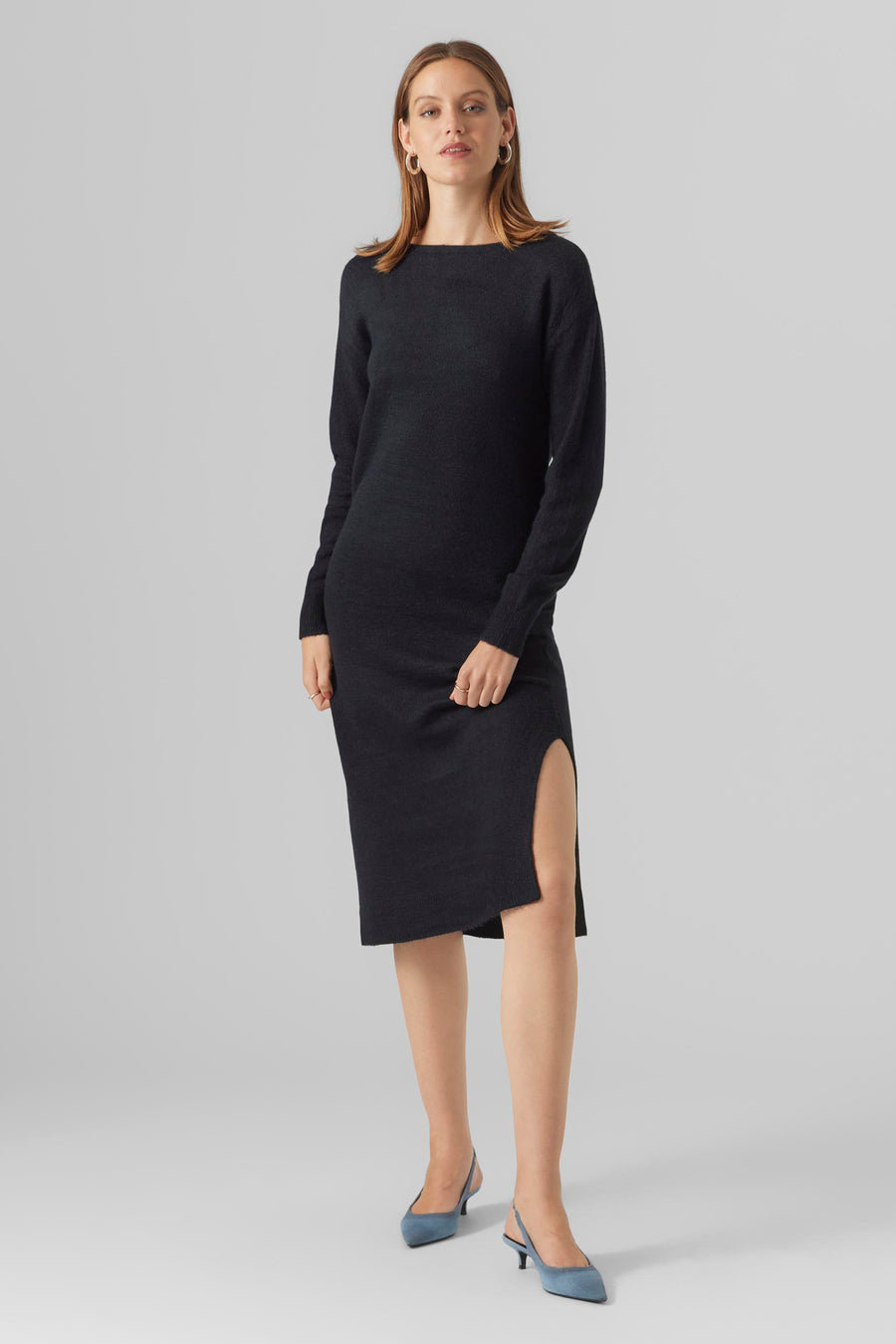 Zwarte midi-jurk van VERO MODA, met een zijsplit en blauwe pumps.
