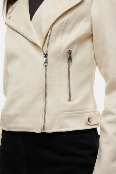 Veste en similicuir beige de VERO MODA, avec fermeture éclair asymétrique et détail de poche à rabat.