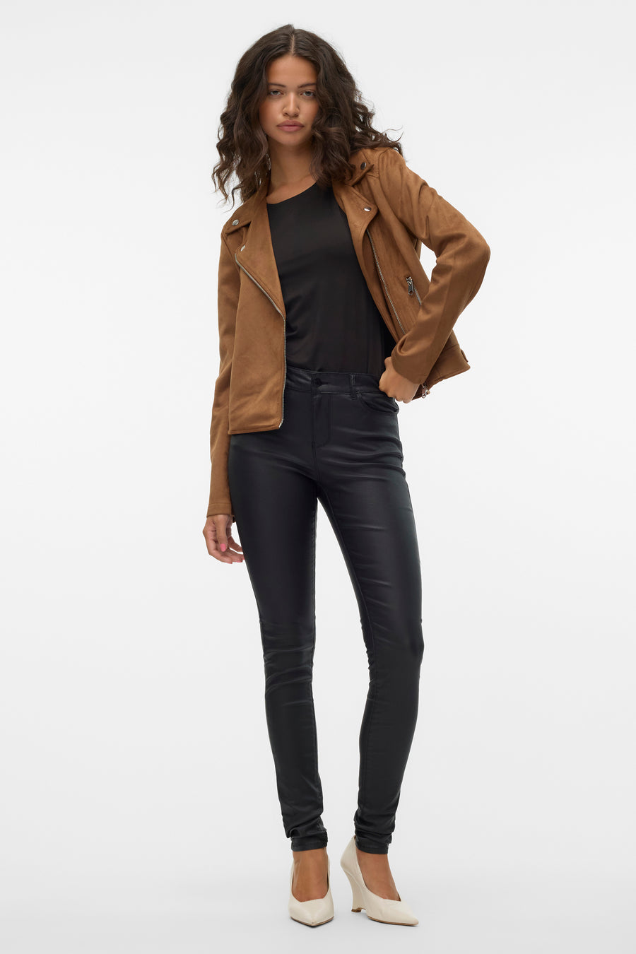 Veste en simili cuir marron de VERO MODA avec fermeture éclair, portée avec un t-shirt noir et un pantalon en cuir noir.