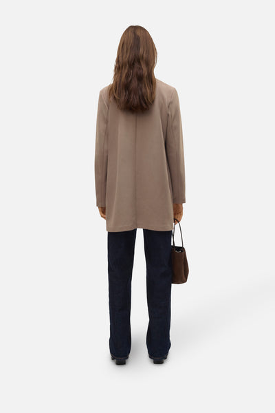 Lange bruine jas van VERO MODA®, gecombineerd met een donkere blauwe broek en eenbruineen,, gez gez van.