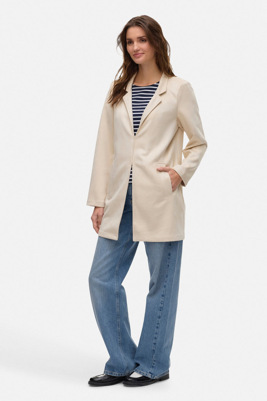 Ecru lange jas van VERO MODA, gedragen over een marineblauw en wit gestreept T-shirt en een wijde blauwe jeans.