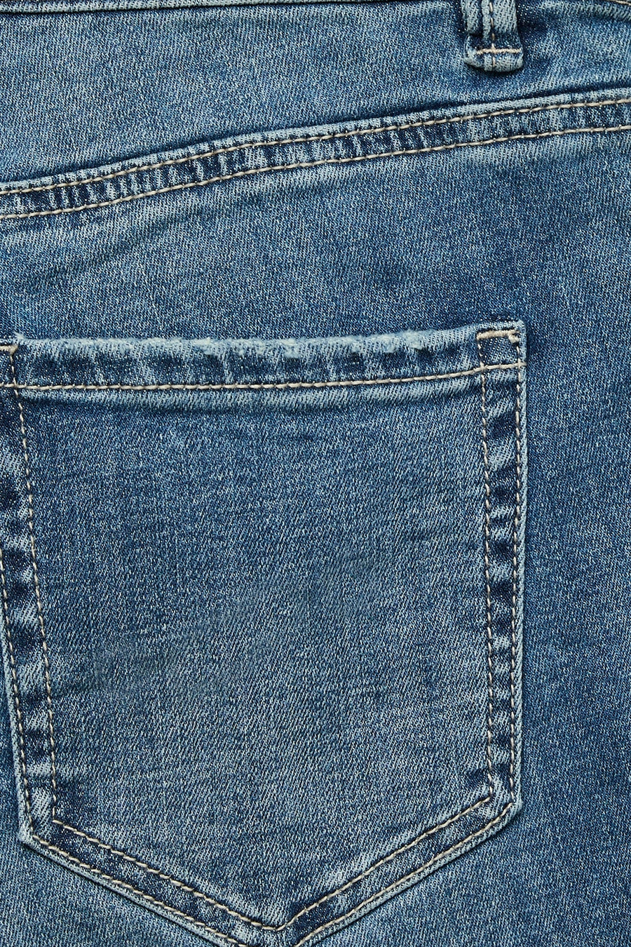 Jean évasé bleu moyen de VERO MODA, détail de couture et poche arrière visible.