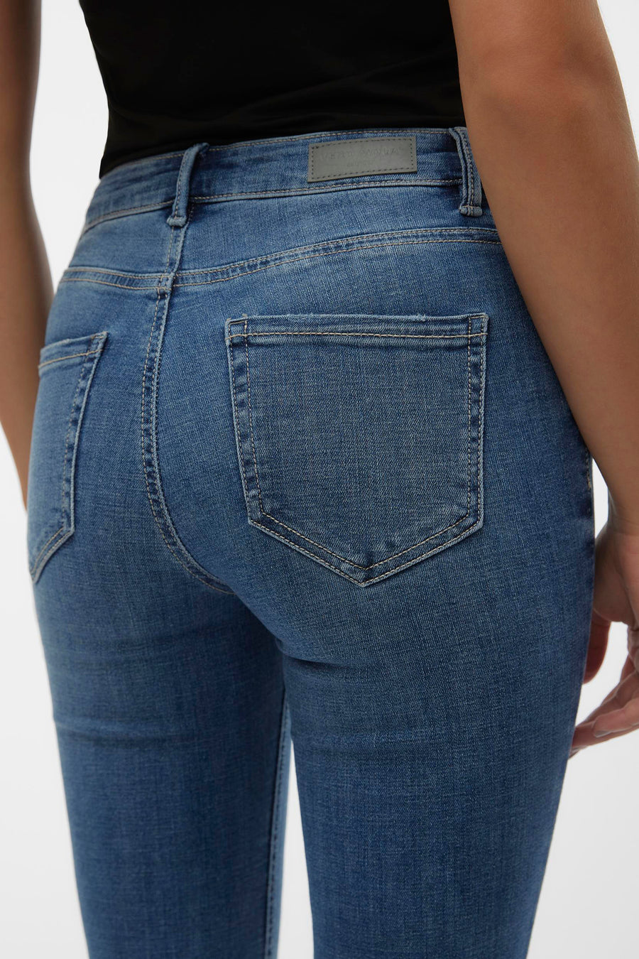 Jean évasé bleu moyen de VERO MODA, avec poches arrière et coutures apparentes.
