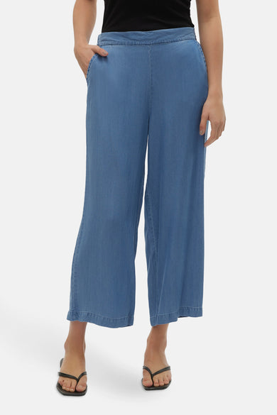 Middelblauwe spijkerbroek van VERO MODA, wijde en korte pijpen, gedragen met een zwarte tanktop en sandalen.
