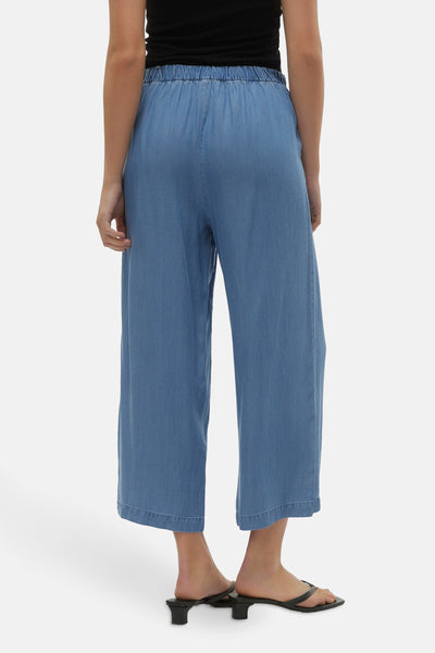 Pantalon denim bleu moyen de VERO MODA, jambe large et taille élastique, porté avec des chaussures noires.
