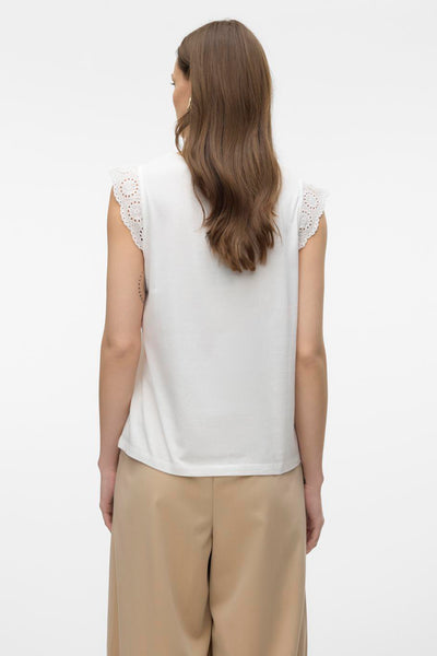 T-shirt blanc à manches courtes de VERO MODA avec détails brodés aux épaules et pantalon beige.
