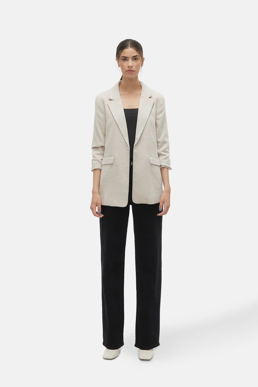 Blazer écru de VERO MODA, porté avec un haut noir et un pantalon noir ample.