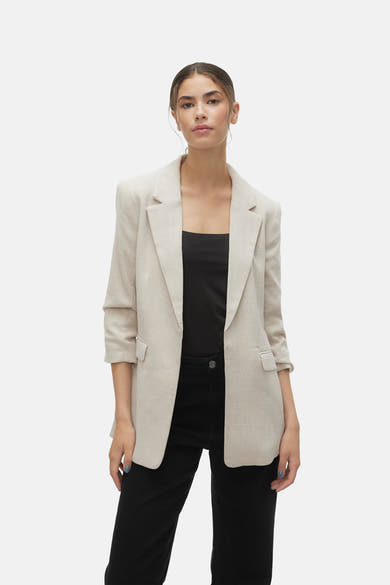 Blazer écru de VERO MODA, porté sur un haut noir et un pantalon taille haute noir.
