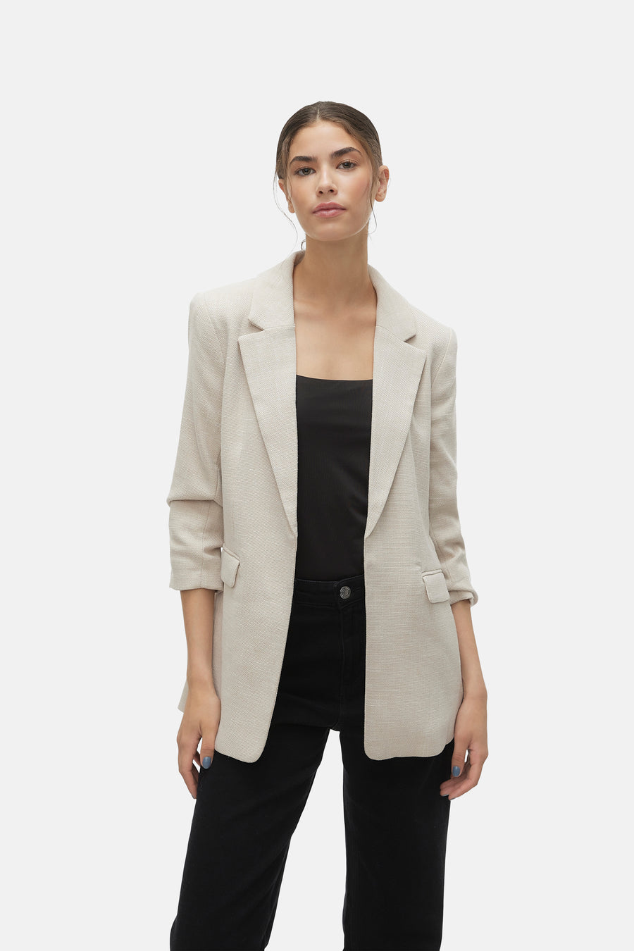 Blazer écru de VERO MODA, porté sur un haut noir et un pantalon taille haute noir.