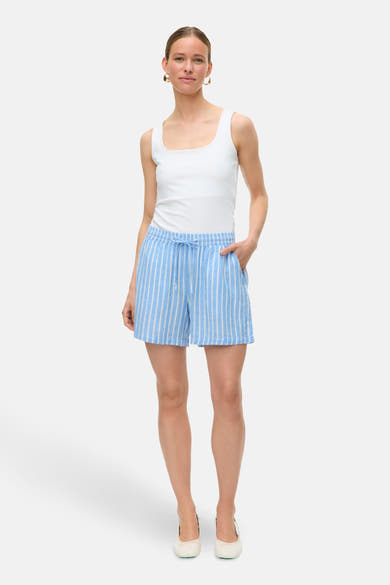 Short rayé bleu de VERO MODA, porté avec un débardeur blanc et des ballerines ivoire.
