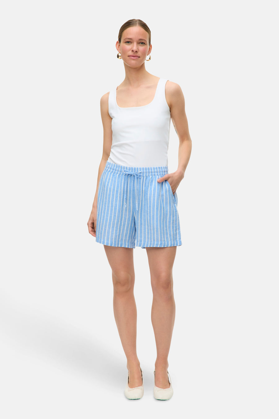 Short rayé bleu de VERO MODA, porté avec un débardeur blanc et des ballerines ivoire.