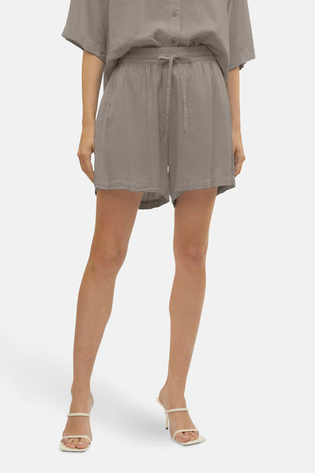 Korte beige short van VERO MODA, gedragen met een bijpassend overhemd en sandalen met hak.