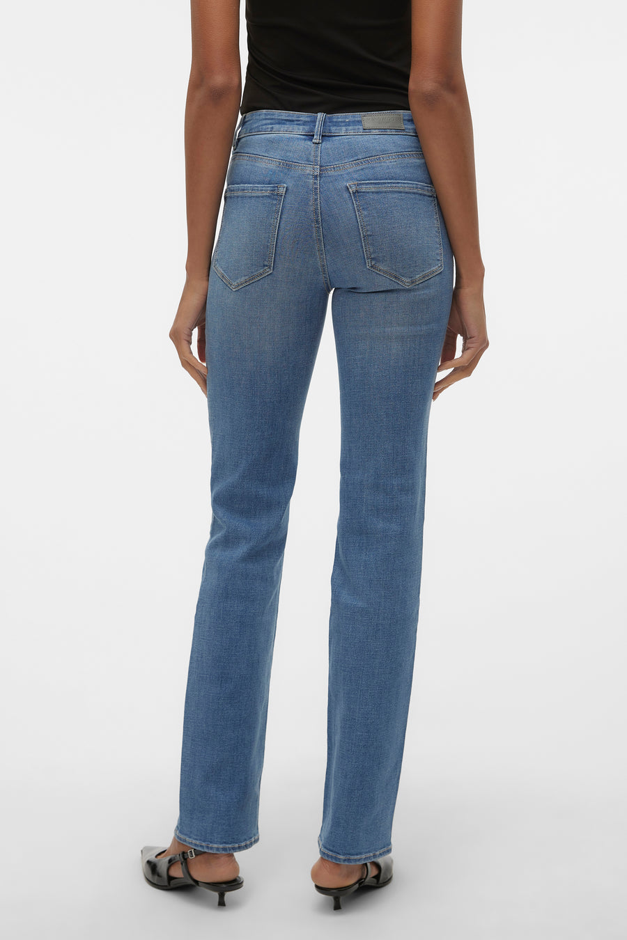 Blauwe rechte jeans van VERO MODA, met achterzakken, gedragen met een zwarte top en zwarte pumps.