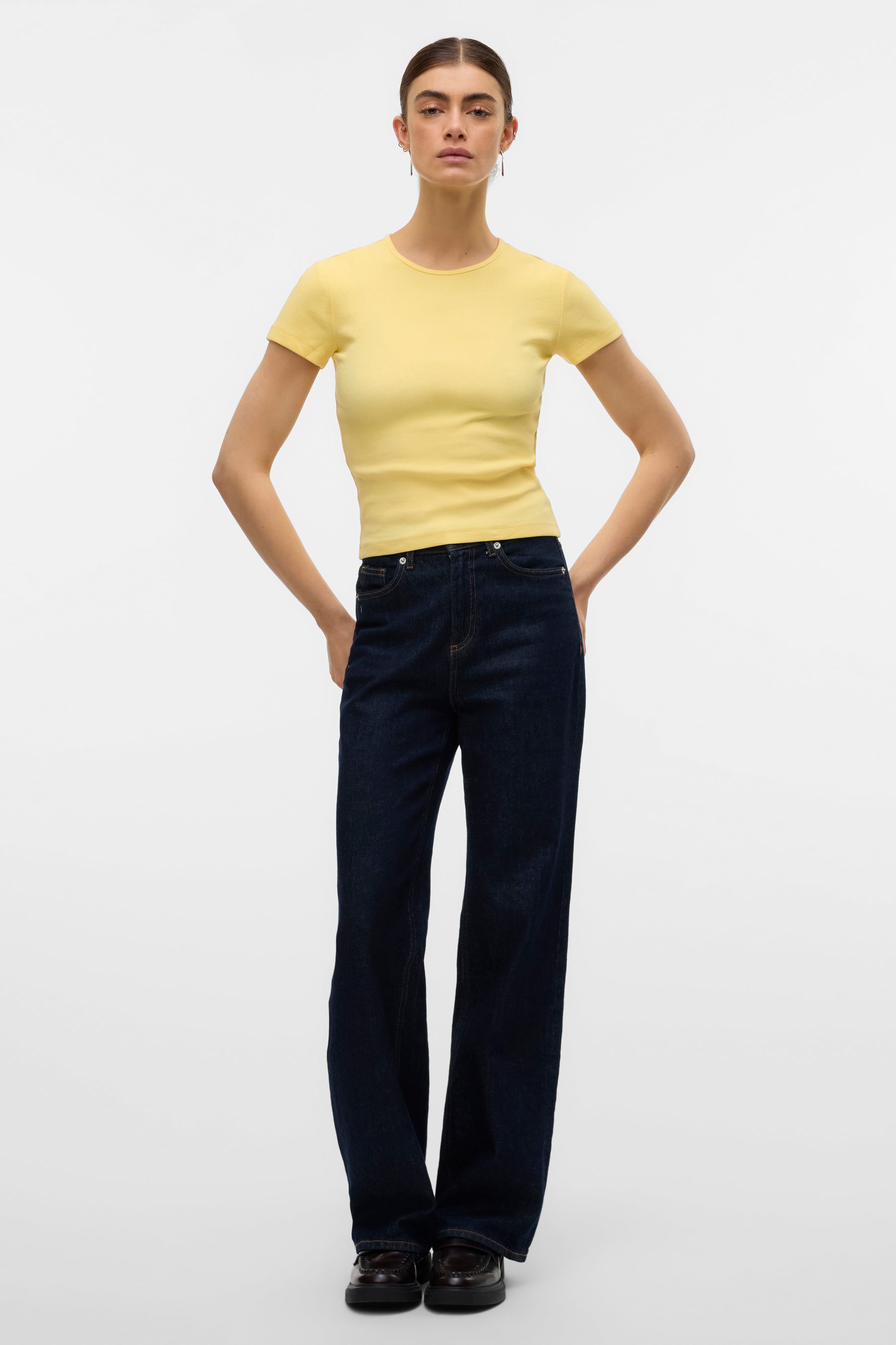 T-shirt jaune à manches courtes de VERO MODA, porté avec un jean indigo et des mocassins en cuir.