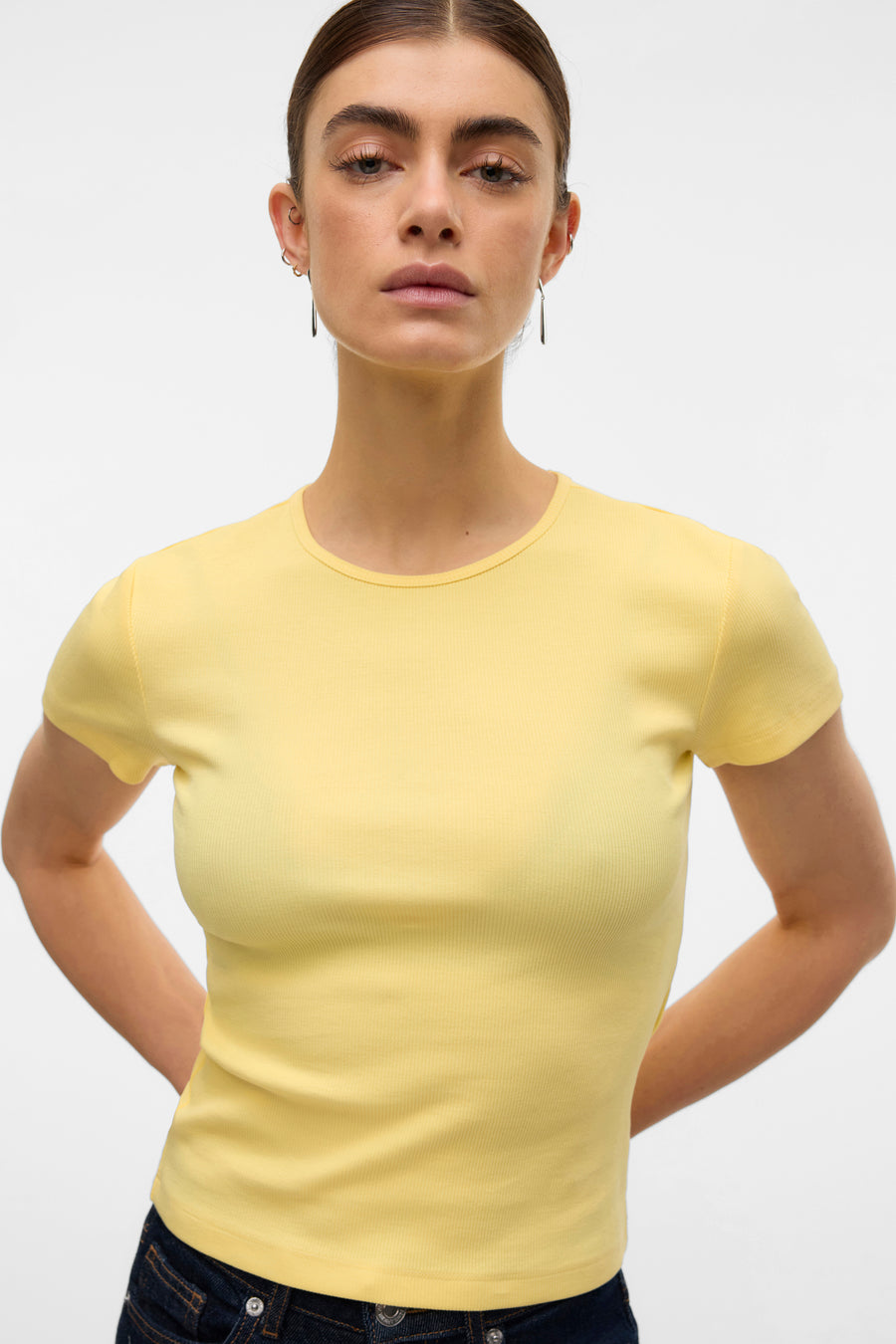 T-shirt jaune à manches courtes de VERO MODA, en jersey côtelé, porté avec un jean.