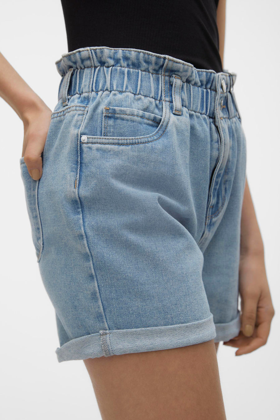 Short en denim bleu clair de VERO MODA, avec taille élastiquée et ourlets retroussés.