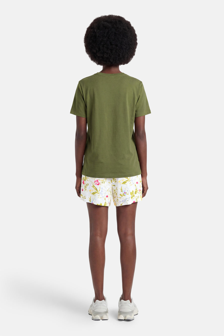 Short blanc à motif floral multicolore de VERO MODA®, porté de dos avec un t-shirt vert olive.