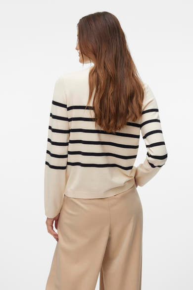 Pull ras du cou en maille écru par VERO MODA® avec rayures horizontales noires, porté avec un pantalon beige.