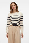 Pull à col rond écru de VERO MODA® avec rayures noires horizontales, porté avec un pantalon beige à taille haute.