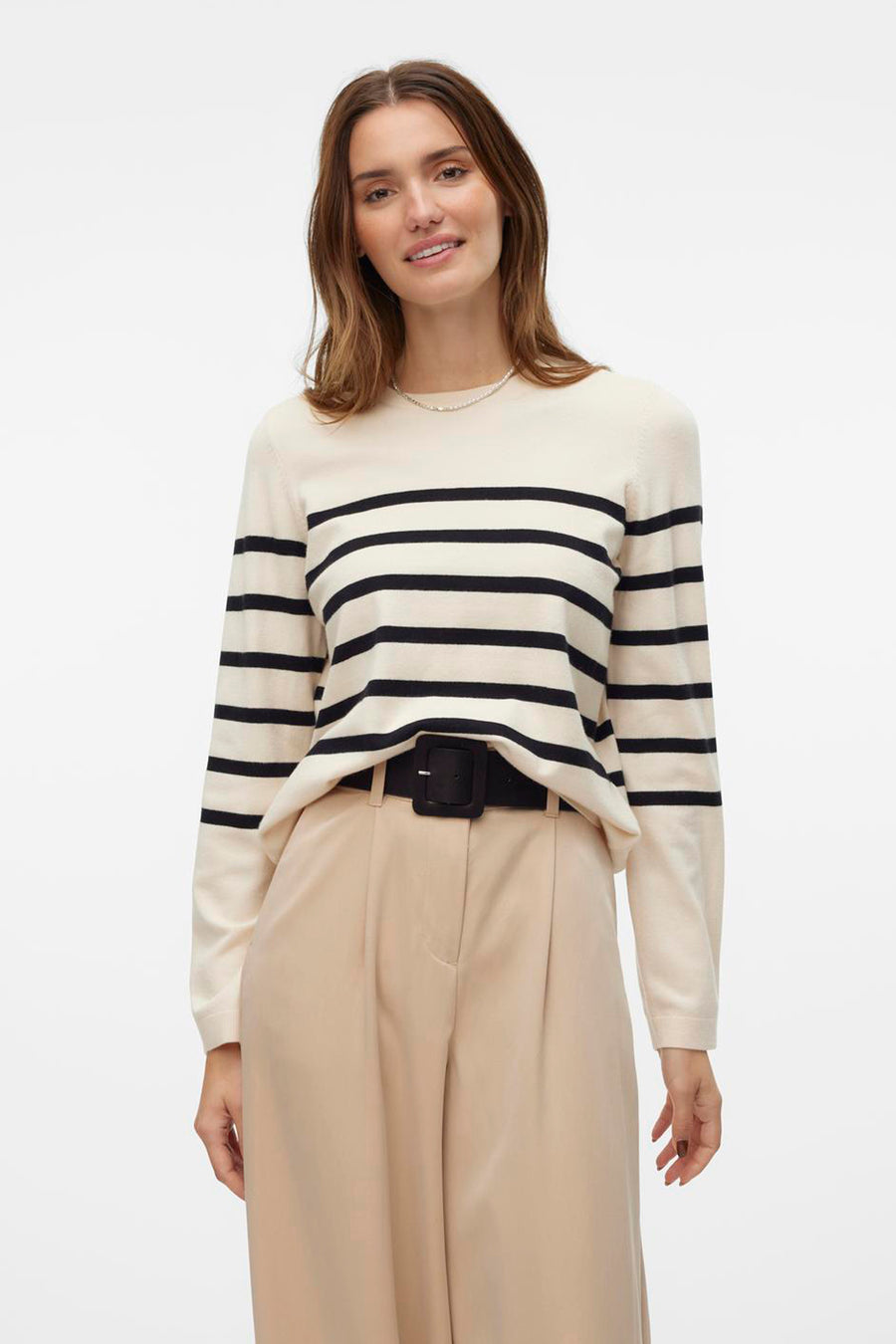 Pull à col rond écru de VERO MODA® avec rayures noires horizontales, porté avec un pantalon beige à taille haute.
