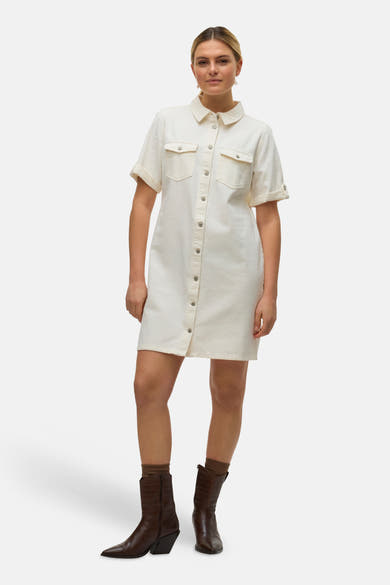 Robe beige de VERO MODA®, à manches courtes et boutonnée, portée avec des bottes marron.