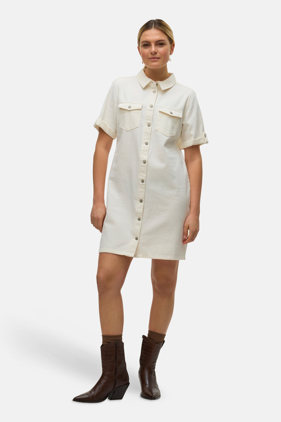 Robe beige de VERO MODA®, à manches courtes et boutonnée, portée avec des bottes marron.