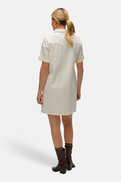 Beige jurk van VERO MODA®, van achteren gezien, gedragen met bruine laarzen en bruine sokken.