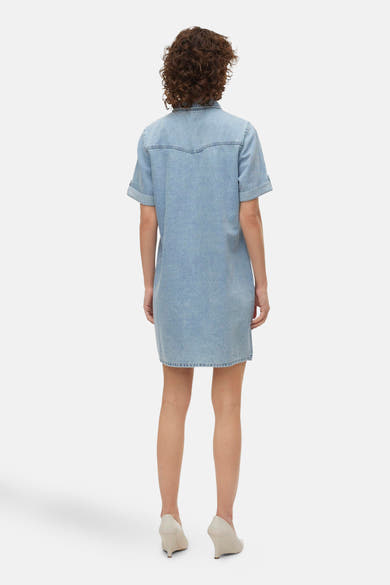 Robe en denim bleu clair de VERO MODA, avec manches courtes et détail western sur le dos.