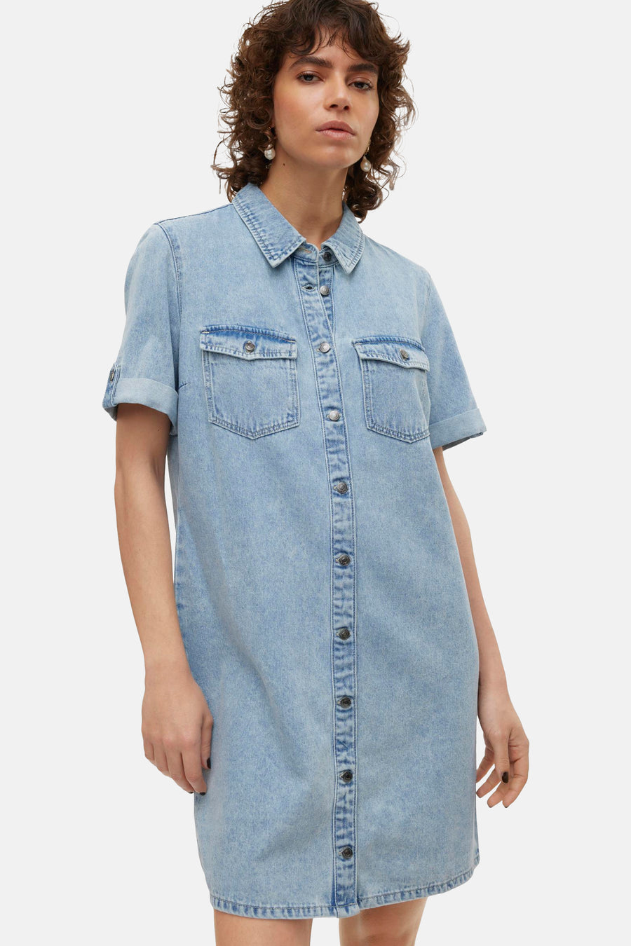 Robe chemise en denim bleu clair de Vero Moda, avec manches courtes roulées et boutons sur toute la longueur.