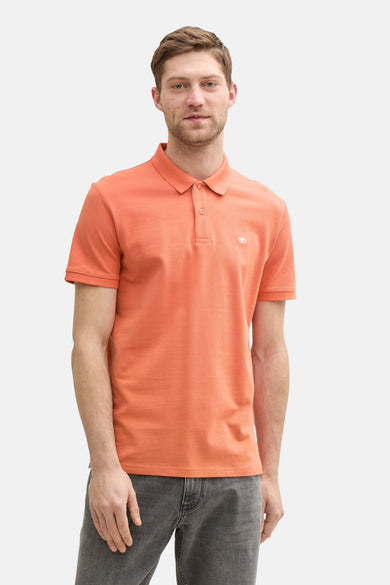 Oranje poloshirt met korte mouwen van Tom Tailor, gedragen met een gemêleerde grijze jeans.