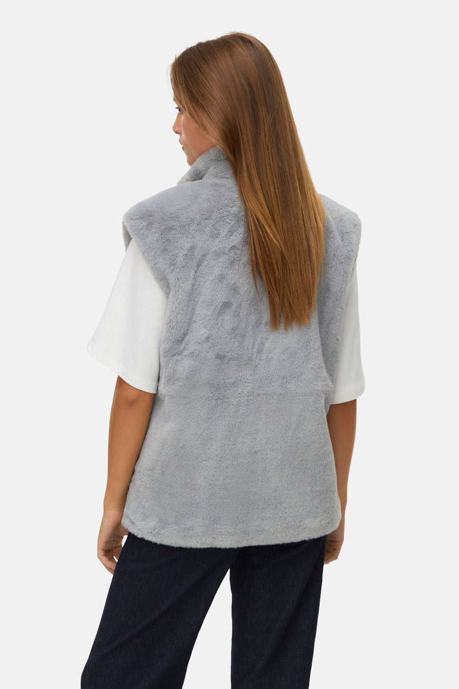 Veste sans manches grise en fausse fourrure de Vero Moda, vue de dos, portée sur un t-shirt blanc et un jean foncé.