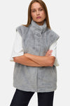 Veste sans manches grise en fausse fourrure de Vero Moda, portée avec un t-shirt blanc à manches courtes.